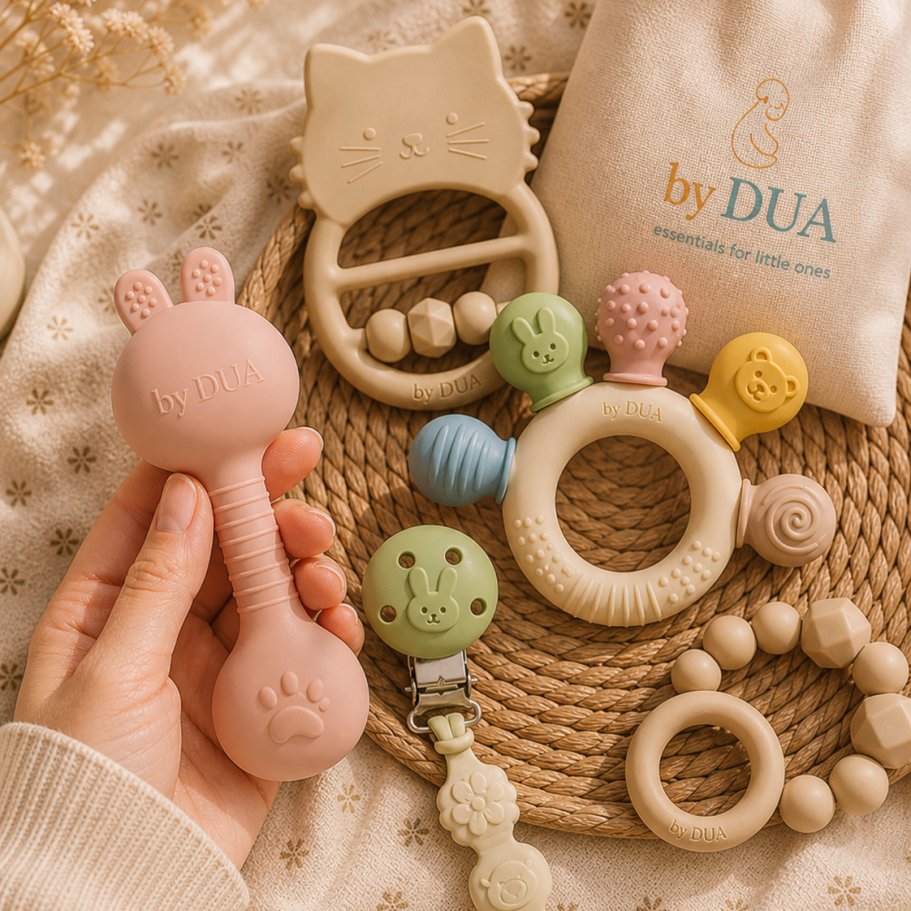 Bunte Babyartikel: Bodysuit, Geschirr, Greifspielzeug und Löffel. by DUA Babybedarf